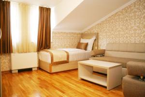 En eller flere senge i et værelse på Hotel Elegance