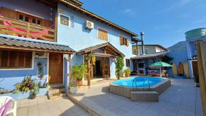 a house with a swimming pool in a courtyard at Nuna Hostel Floripa in Florianópolis