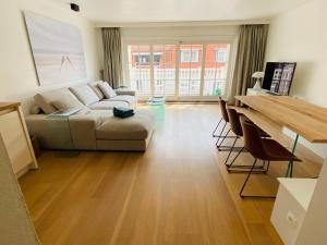 - un salon avec un canapé et une table dans l'établissement Appartement moderne 2 chambres et grand balcon, à Knokke-Heist
