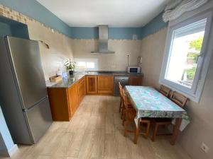 uma cozinha com uma mesa e um frigorífico em Chalet Rialeda em Oleiros