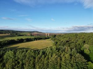 una vista aerea di un edificio nel mezzo di una foresta di Doura Lodge a Inverness