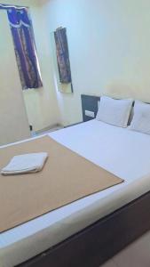 a large bed in a room with a mirror at Hotel Gitanjali in Ahmedabad