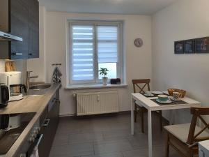 eine Küche mit einem Tisch und einem Fenster in der Unterkunft Altstadt Domizil in Pirna