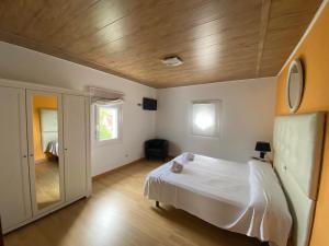 a bedroom with a white bed and a wooden ceiling at Chalet Rialeda in Oleiros