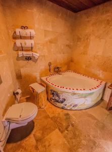 a bathroom with a tub and a toilet at My Story Cave Hotel in Uçhisar