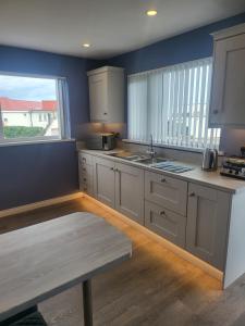 a kitchen with white cabinets and a large window at Royal Court Hotel in Portrush