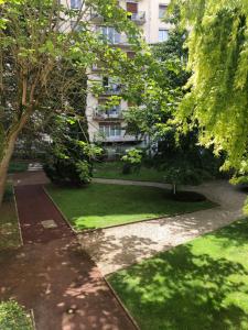 ogród z trawą i budynek w tle w obiekcie Studio 96 - Wi fi fibre - Résidence Beauséjour - Proche centre ville w Troyes