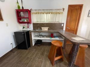 eine Küche mit einer Theke, einem Waschbecken und einem Tisch in der Unterkunft Darwin's temple in San Cristobal