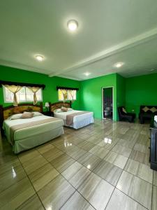 1 dormitorio con 2 camas y paredes verdes en Hotel Pazifico en Monterrico, en Monterrico