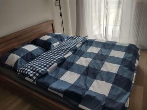 a bed with a blue and white checkered blanket at STARA CEGIELNIA, Faktura VAT, bezkontaktowe zameldowanie in Poznań