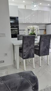 eine weiße Küche mit einem weißen Tisch und Stühlen in der Unterkunft Apartments Pepdjonovic in Ulcinj