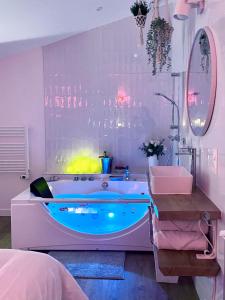 ein Badezimmer mit einer blauen Badewanne und einem Waschbecken in der Unterkunft Cocon de ville in Issoire