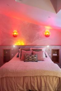 1 dormitorio con 1 cama grande y paredes de color rosa en Cocon de ville, en Issoire