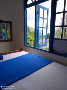 a bedroom with two beds and an open window at Green View Ella in Ella