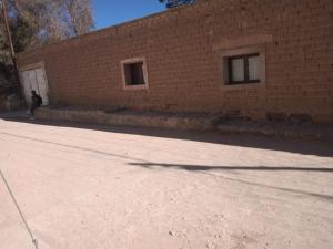 una persona caminando frente a un edificio de ladrillo en Casa La Chacra en Humahuaca