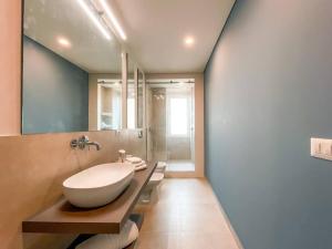 y baño con lavabo blanco grande y ducha. en Myosotis luxury apartment, en Siracusa