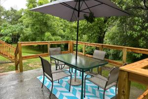una mesa y sillas con una sombrilla en la cubierta en Tennessee Harmony, en Sevierville