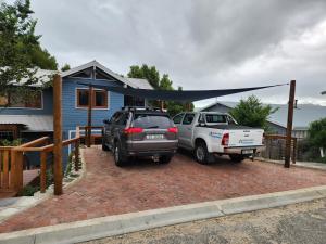 a car and a truck parked in front of a house at Knysna Holiday Armadillo in Knysna