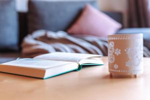 a book and a cup of coffee on a table at Pool House Merano in Merano