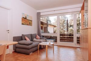 a living room with a couch and a table at Pool House Merano in Merano
