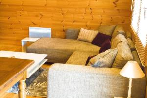 ein Wohnzimmer mit Sofa und Tisch in der Unterkunft Cottage autour de l'étang 80 in Bourbourg