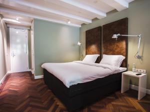 a bedroom with a white bed and white walls at Herengracht B&nB in Amsterdam