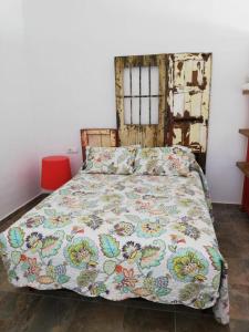 a bedroom with a bed with a colorful bedspread at La pinza bl am in El Palmar +12 photos