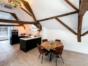 una cucina e una sala da pranzo con tavolo e sedie in legno di B&B aan de Markt a Roermond
