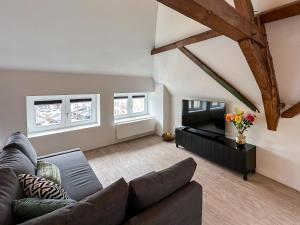 a living room with a couch and a tv at B&B aan de Markt in Roermond