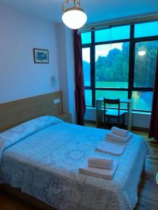 1 dormitorio con 1 cama con toallas en Hostal Pumar, en Santiago de Compostela