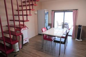 uma sala de jantar com uma mesa e cadeiras e uma escada em BreezyBlue - Vacation STAY 64820v em Awaji