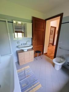 ein Badezimmer mit zwei Waschbecken, einem WC und einem Spiegel in der Unterkunft Villa Gattoni Cattaneo - Appartamento Le Magnolie in Lardara
