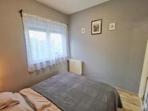 a bedroom with a bed and a window at Panoráma Garden in Zalakaros