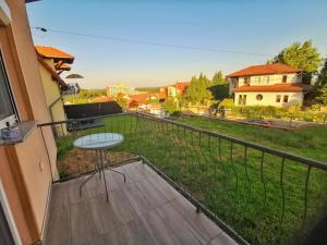 a balcony with a table and a view of a yard at Panoráma Garden in Zalakaros