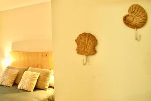 1 dormitorio con 1 cama y 2 sombreros en la pared en Apartamento Brisas, en Moaña