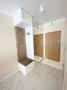 a dressing room with white cabinets and marble floors at Glamor Lux in Gdańsk