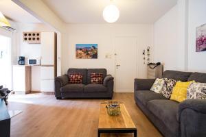 ein Wohnzimmer mit 2 Sofas und einem Couchtisch in der Unterkunft XiangBaLa in Athen