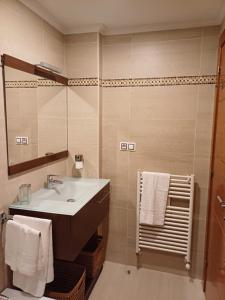 ein Bad mit einem Waschbecken und einem Spiegel in der Unterkunft Apartamento Galería Gijón in Gijón