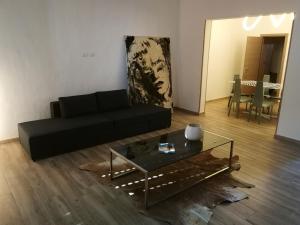 een woonkamer met een zwarte bank en een glazen tafel bij DonaLisa in Andrano