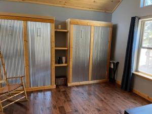 um quarto com portas de madeira, uma cadeira e uma janela em RidgeWalk Main House em Angel Fire
