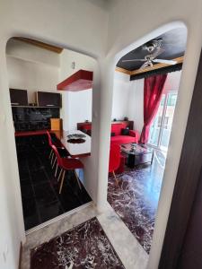 a kitchen and living room with red chairs and a table at ~Lovey-Dovey~ nice & central apartment ~Sitia~ in Sitia