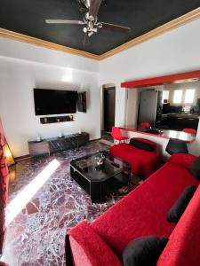 a living room with red furniture and a flat screen tv at ~Lovey-Dovey~ nice & central apartment ~Sitia~ in Sitia