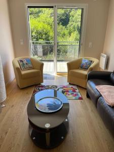 ein Wohnzimmer mit zwei Stühlen und einem Couchtisch in der Unterkunft Le B4 - Résidence La Montille in Le Mont-Dore