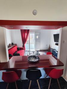 a living room with a dining table and red chairs at ~Lovey-Dovey~ nice & central apartment ~Sitia~ in Sitia