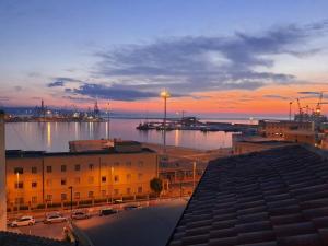 een uitzicht op een stad met een haven bij zonsondergang bij La Finestra sul Porto Apartment in Ancona