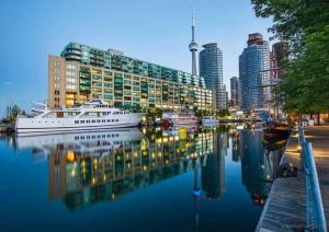 a city skyline with a boat in the water at Beautiful 1BD 1BA Condo Lake and City Views in Toronto