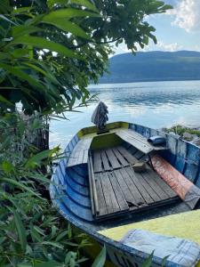 um pequeno barco sentado na costa de uma massa de água em ROLEO Guest House em Lin