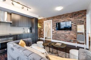 a living room with a couch and a brick wall at 3BR Rooftop Pool Gym Steps to MTCC and CN Tower with Parking in Toronto