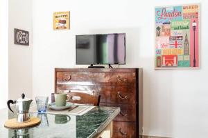 um quarto com uma mesa e uma televisão numa cómoda em Casa dei quadri monolocale Jesi em Iesi