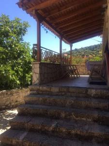 a set of stairs leading to a porch with a pergola at Traditional village house on Argolis for 6 persons in Kariá